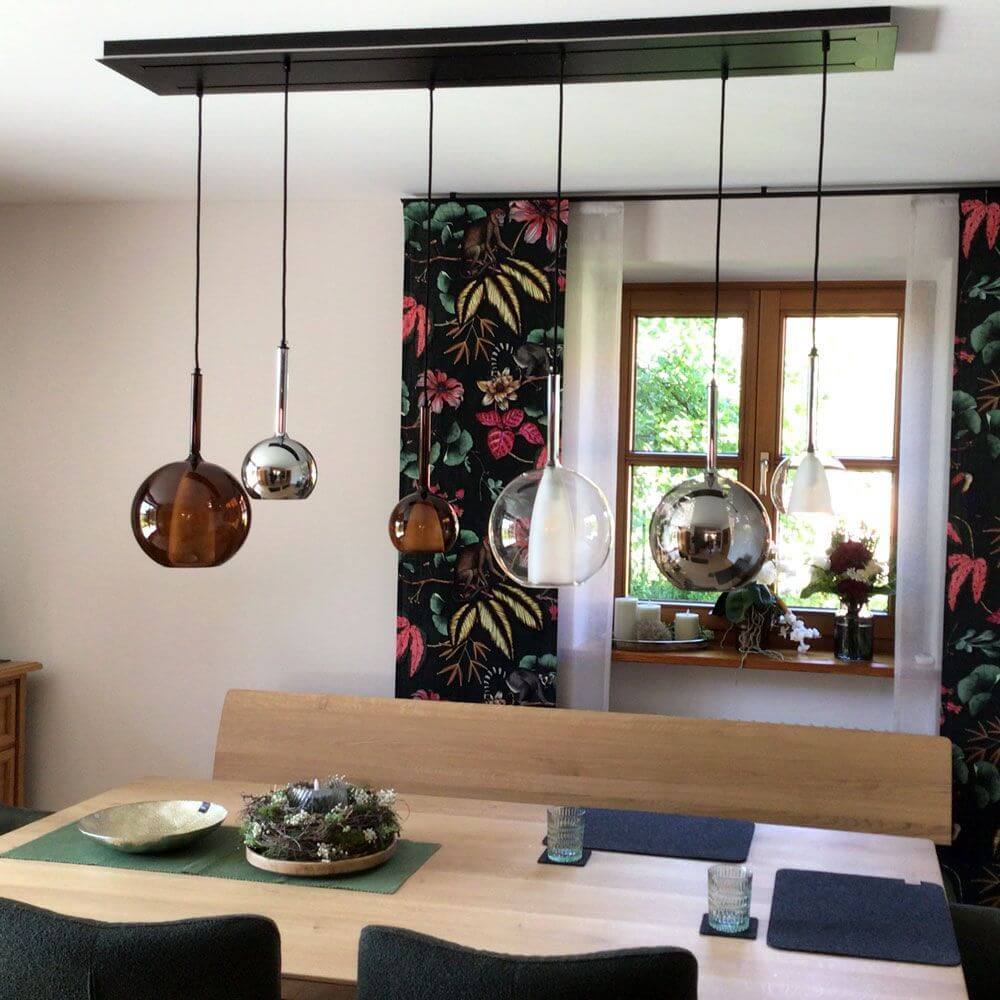 s.luce Belluna Esstischlampe 12-flammig 200cm 3-reihig über einem Holz-Tisch in modernem Esszimmer.