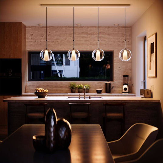 Moderne Küche mit stilvollen Pendelleuchten, Holzoberflächen und einem eleganten Tisch. Gemütliche Atmosphäre.