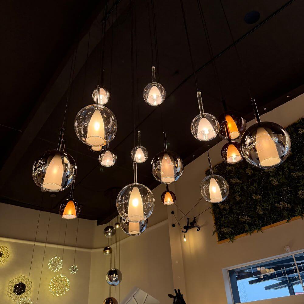 s.luce Belluna Esstischlampe 12-flammig 200cm 3-reihig in einem modernen Raum mit stilvollen Glaskörpern