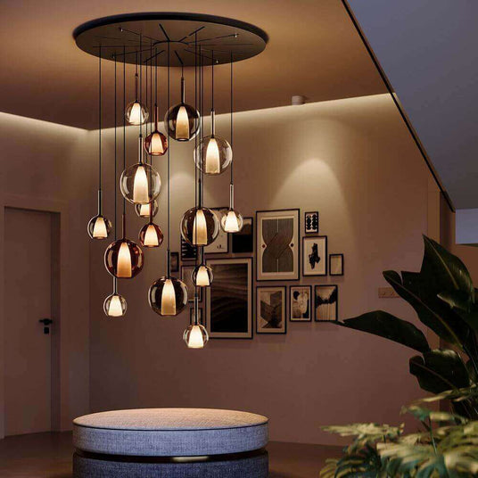 Moderne Hängeleuchte mit stilvollen Glaskugeln in einem eleganten Raum mit Kunstwerken.