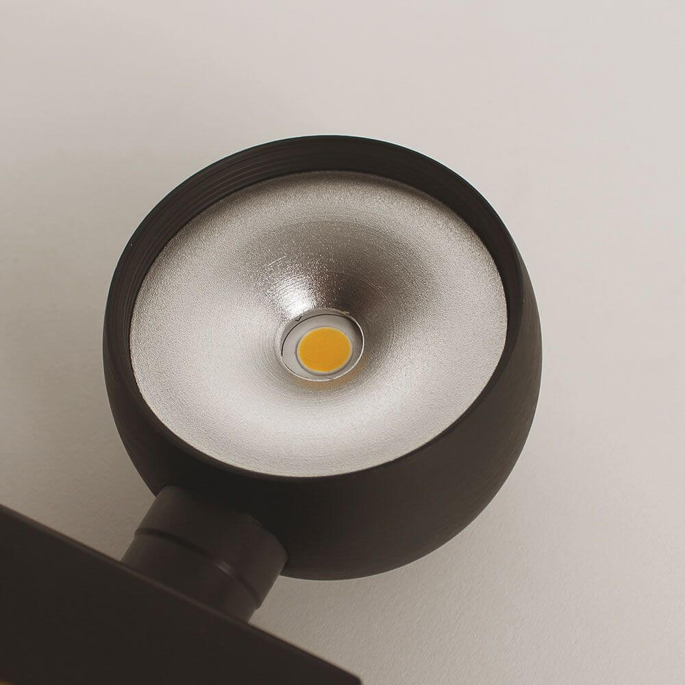 Close-up of the s.luce Beam LED lamp with silver reflector surface and yellow LED element.
