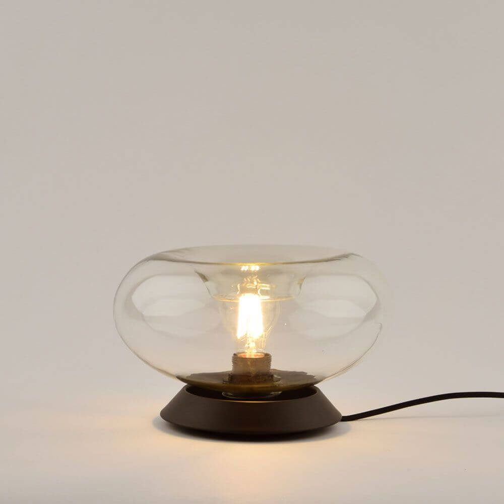 s.luce Cruet E27 Design Tischleuchte Glas mit Schalter auf schwarzem Sockel, leuchtend in modernem Design.