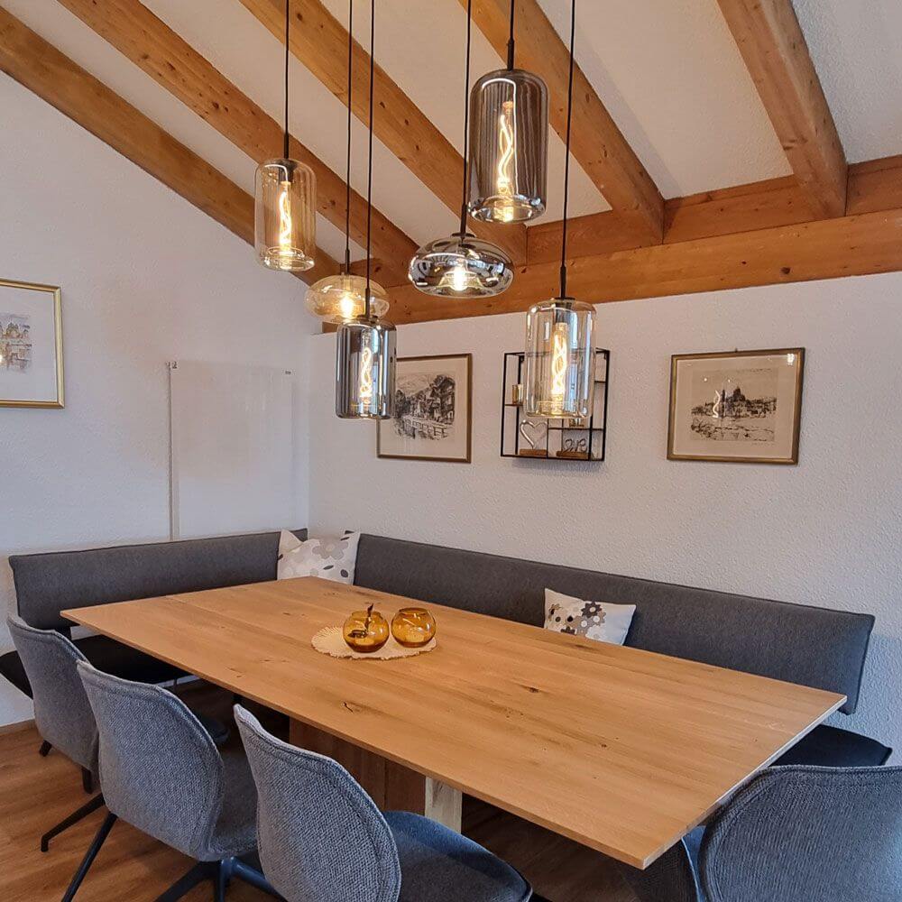 s.luce Cruet Low Esstisch-Pendelleuchte 1-Phasen-Schiene Endeinspeiser über einem modernen Holztisch in stilvollem Essbereich.