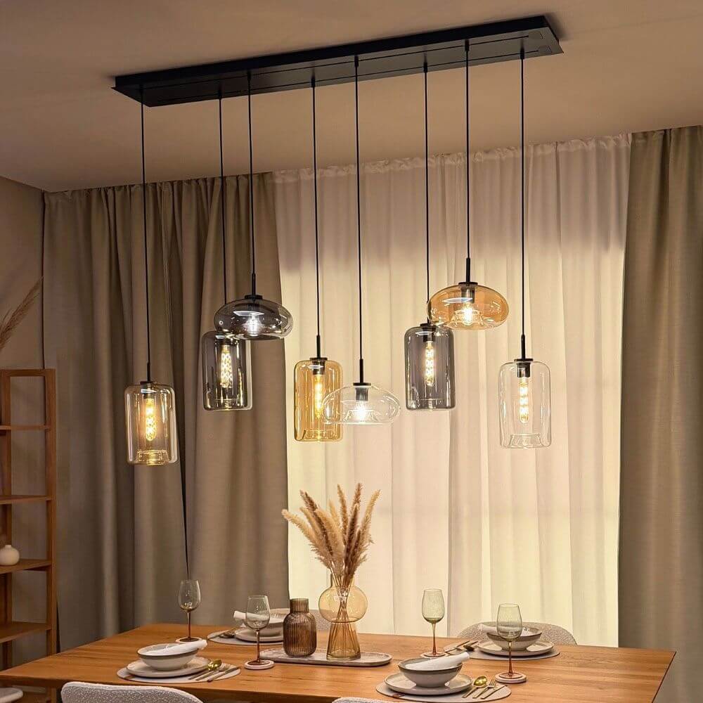 s.luce Cruet Up Esstisch-Pendelleuchte 2 bis 5-flammig 120cm über einem Esstisch mit dekorativen Glaskugeln.