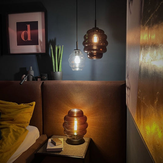 s.luce Echos Glas Tischleuchte E27 mit Schalter auf einem Nachttisch in einem modernen Schlafzimmer.