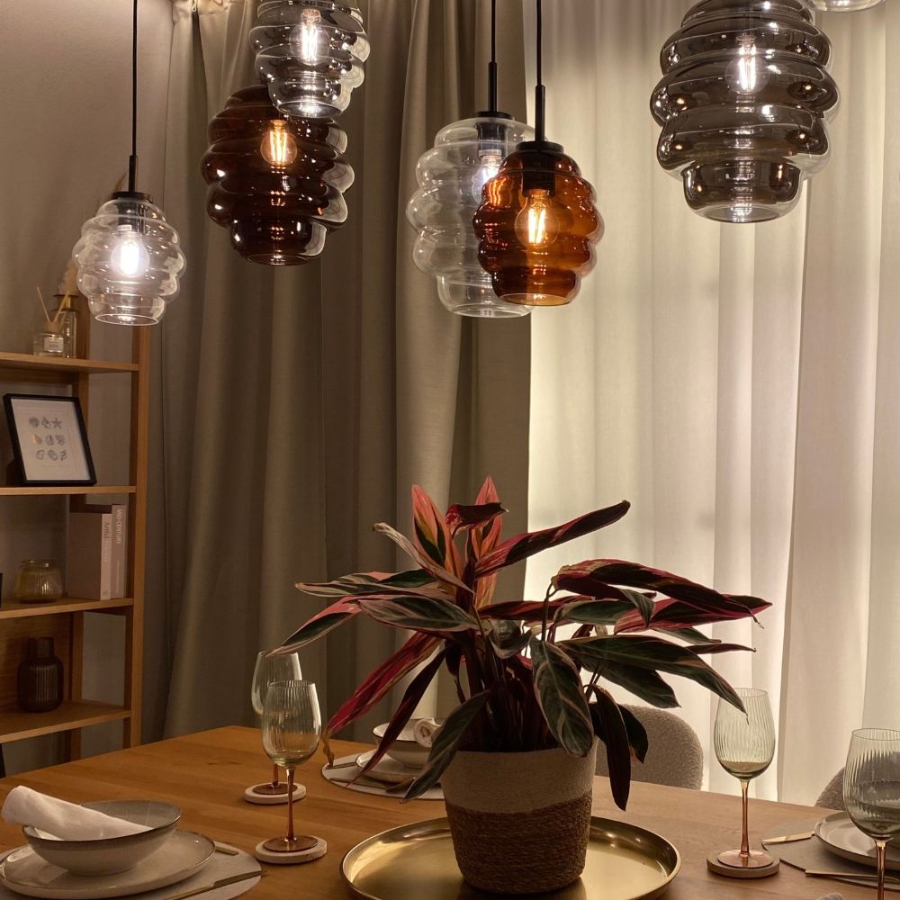 s.luce Echos Esstischlampe 8-flammig 200cm 3-reihig Ø 18/25cm hängend über einem Esstisch mit Pflanzen.