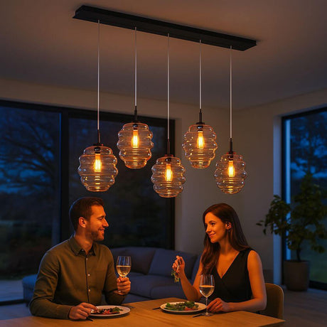 s.luce Echos Esstischleuchte 5-flammig 160cm Baldachin Ø 25cm über einem Esstisch mit zwei Personen.