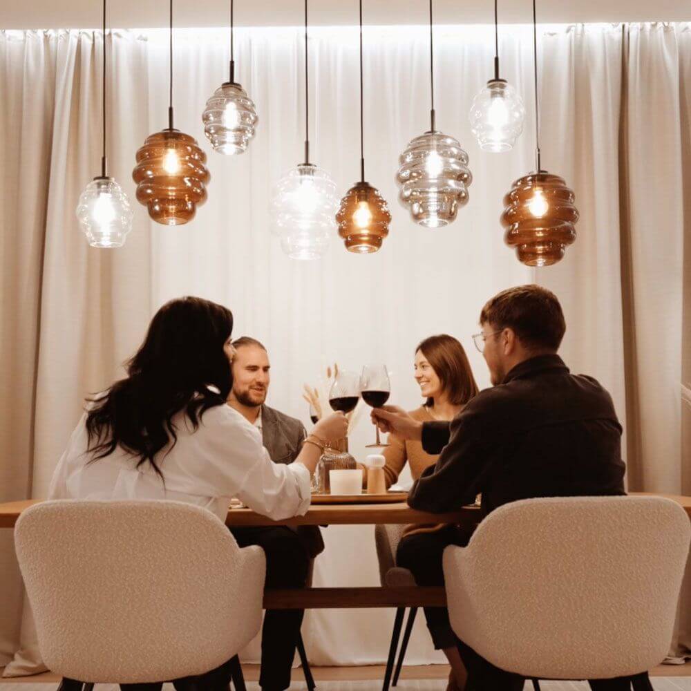 s.luce Echos Esstischleuchte 5-flammig 160cm Baldachin Ø 25cm über einem Esstisch in einem modernen Raum.