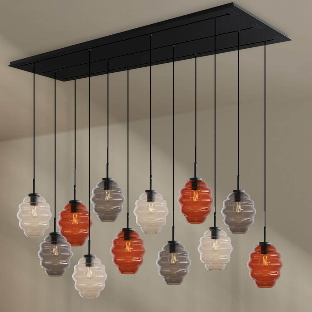 s.luce Echos Esszimmerlampe 12-flammig 200cm 3-reihig Ø 18cm mit bunten Glaskörpern über einem Tisch.