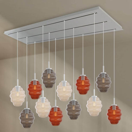 s.luce Echos Esszimmerlampe 12-flammig 200cm 3-reihig Ø 18cm mit bunten Glaskörpern über einem Esstisch