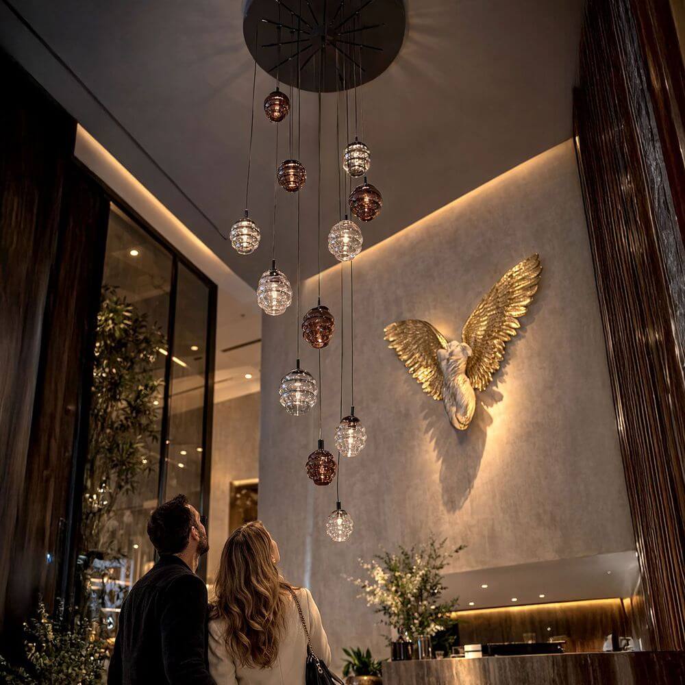 s.luce Echos Galerieleuchte 12-flammig Ø 80cm Baldachin Ø 18/25cm hängende Glas-Pendelleuchte in Cognac, Rauch und Klar über Hotellobby