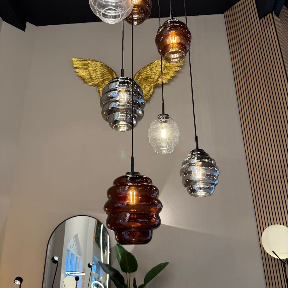 s.luce Echos Glas-Hängelampe Aufhängung 150cm Weiß in einem modernen Interieur mit goldenen Flügeln.