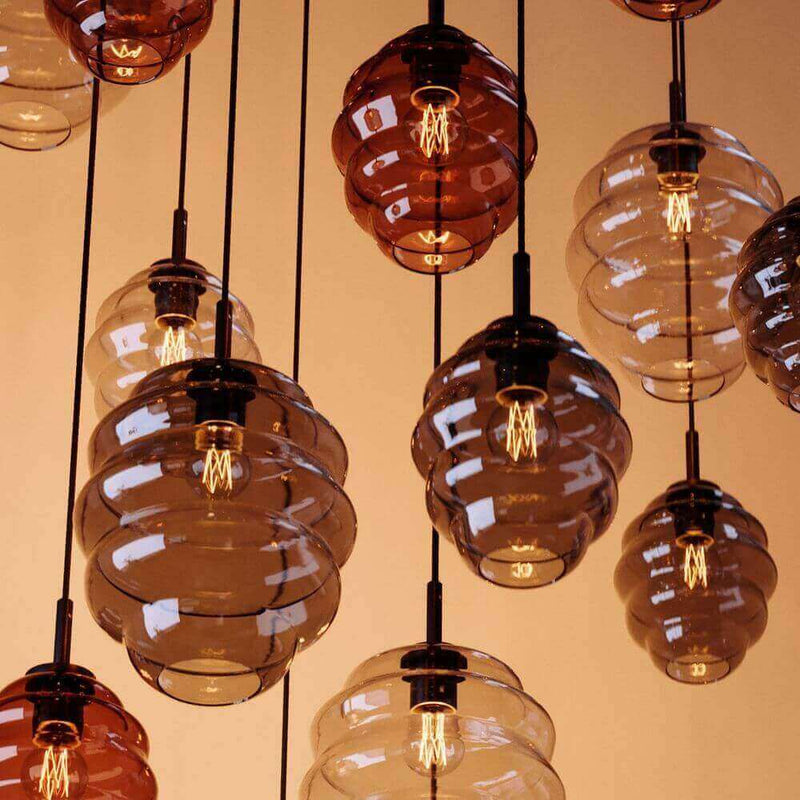 Hängende Glühbirnen-Lampen in verschiedenen transparenten Farben für stilvolle Innenräume.