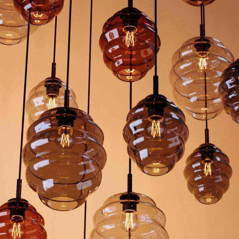 Hängende Glühbirnen-Lampen in verschiedenen transparenten Farben für stilvolle Innenräume.