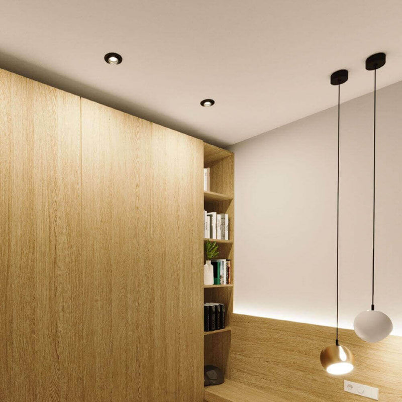 s.luce Beam Einbauspot mit Glaslinse Ø 11cm in modernem Wohnraum mit Holzregal und Pendelleuchten.
