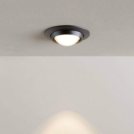 Deckeneinbauleuchte mit modernem, schwarzem Design und warmem Licht auf einem neutralen Hintergrund.