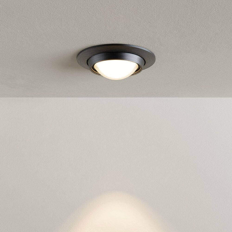 Deckeneinbauleuchte mit modernem, schwarzem Design und warmem Licht auf einem neutralen Hintergrund.