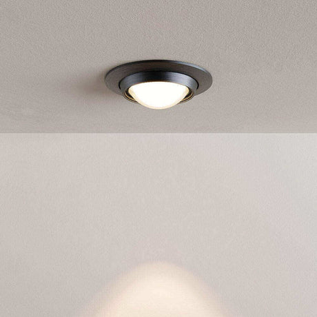 Deckeneinbauleuchte mit modernem, schwarzem Design und warmem Licht auf einem neutralen Hintergrund.