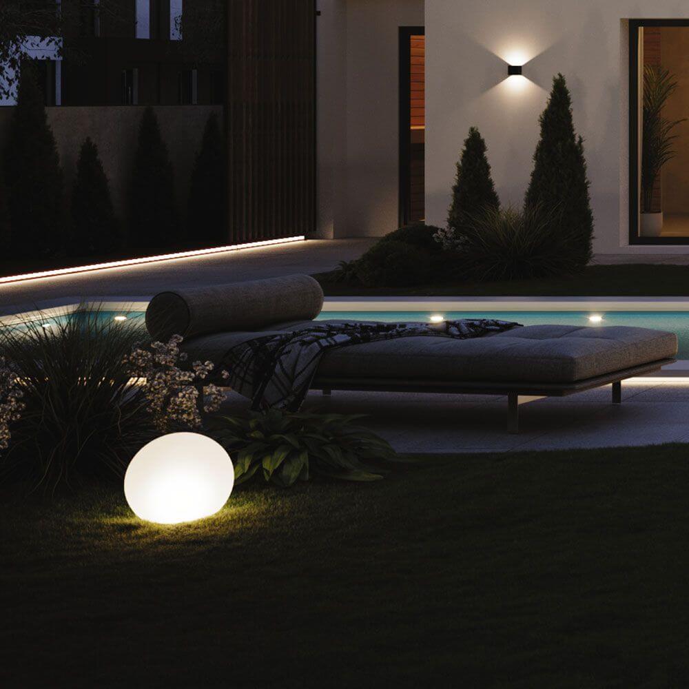 s.luce Globe Set Garten Kugelleuchten neben einer eleganten Terrasse mit modernem Pool und stilvoller Beleuchtung.