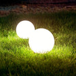 s.luce Globe Kugelleuchten in Weiß auf grünem Rasen, ideal für stimmungsvolle Außenbeleuchtung.