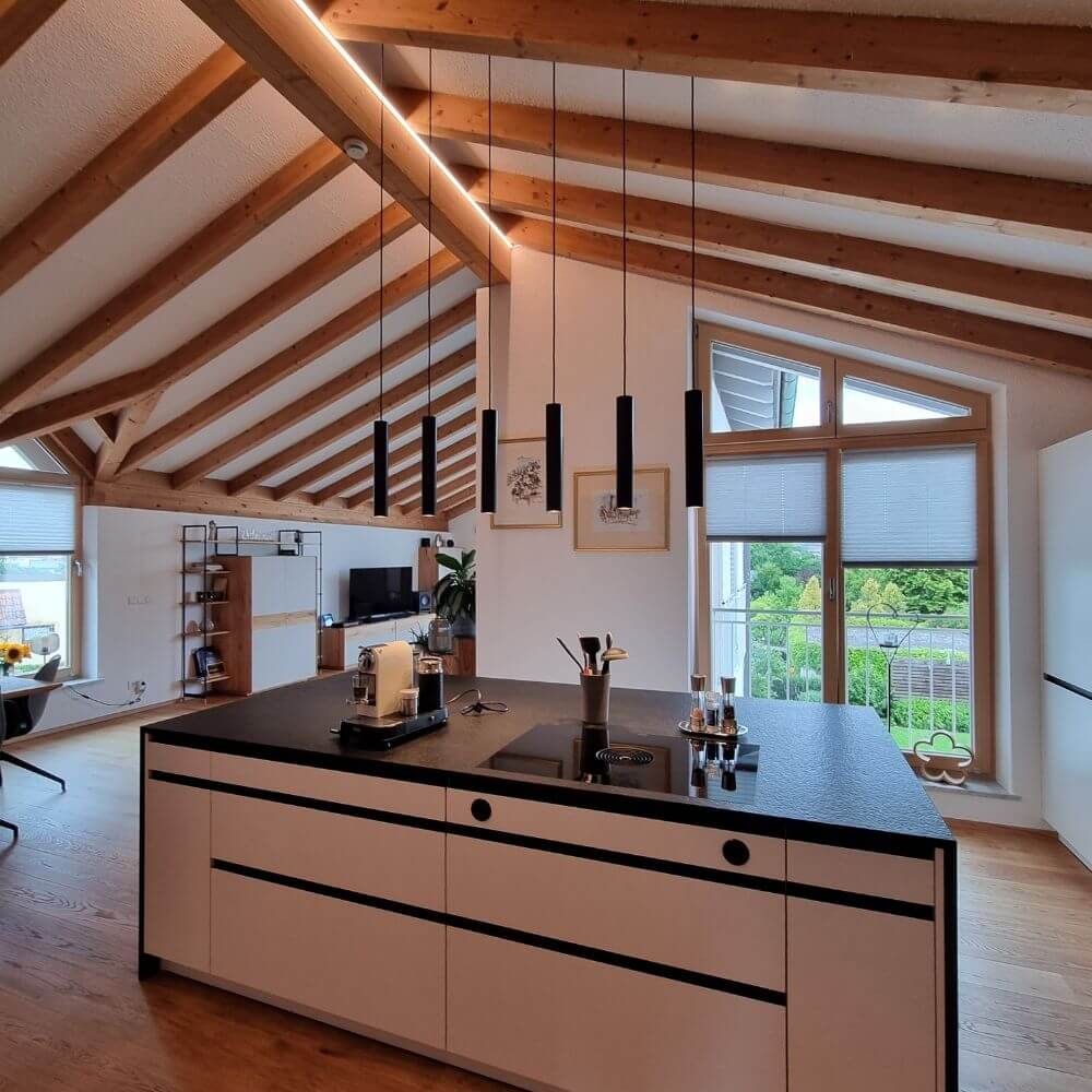 s.luce Lampada a sospensione moderna Crutch a forma di cilindro in un ambiente cucina moderno con travi in legno.