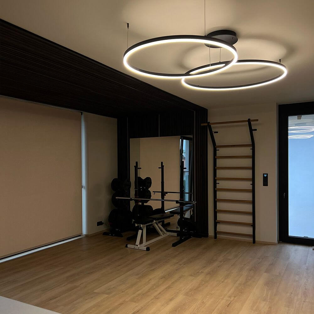 s.luce LED Suspension Ring à 2 lampes excentrée dans un espace moderne avec parquet en bois.