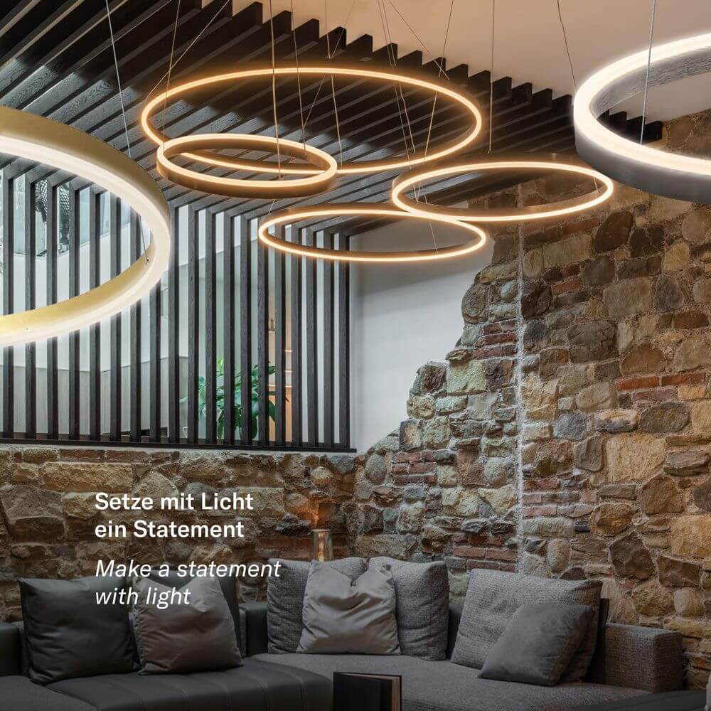 s.luce LED Ring Pendelleuchte rund Direkt oder Indirekt in modernem Wohnraum mit Steinwand.