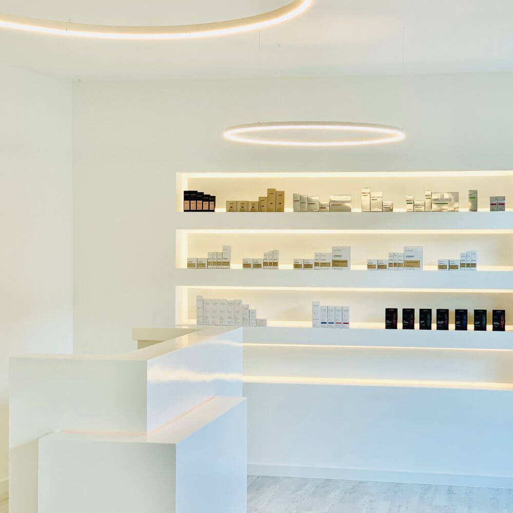 s.luce LED Ring Pendelleuchte rund Direkt oder Indirekt in modernem Verkaufsraum mit beleuchteten Regalen.