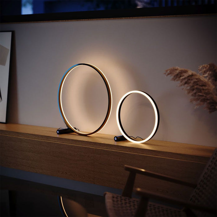 s.luce LED Ring table lamp direct or indirect on an elegant wooden surface, modern and stylish.
