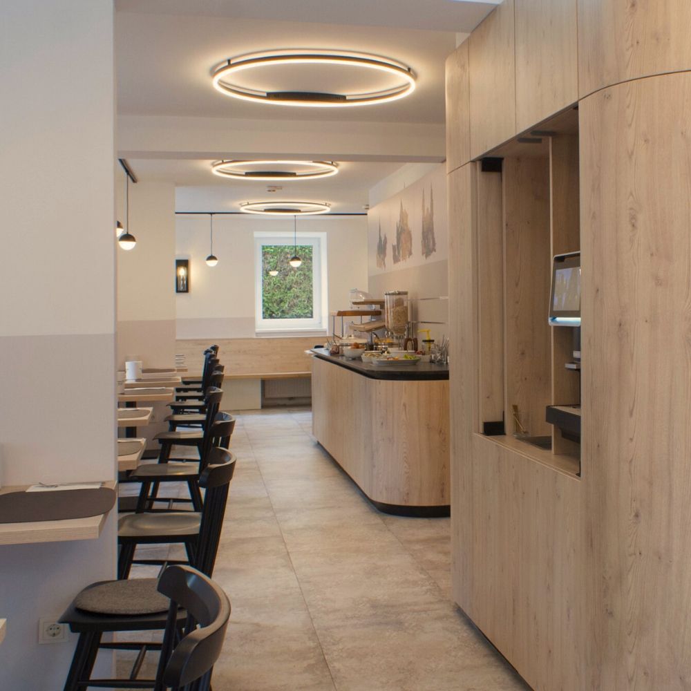 s.luce LED Aplique de parede e plafon Ring regulável, moderno, redondo, num interior moderno com superfícies em madeira.