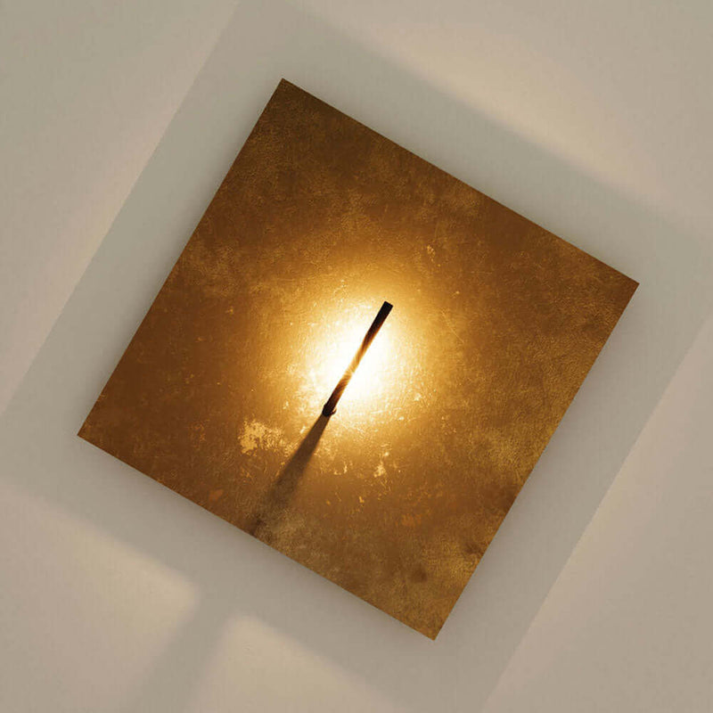 Wandlampe in quadratischer Form mit goldener Oberfläche und minimalistischem Design.