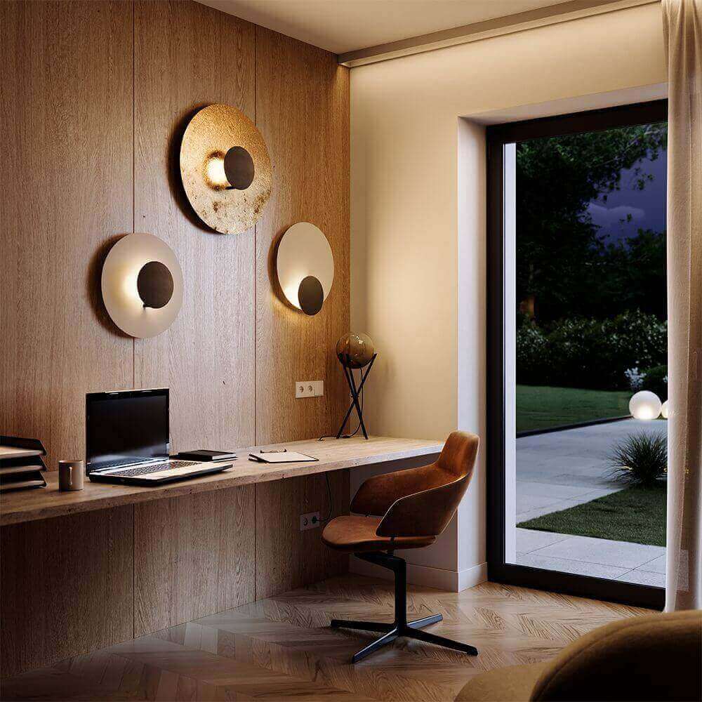 Modern home office with wooden walls, stylish lighting, and a cozy chair near a garden view.