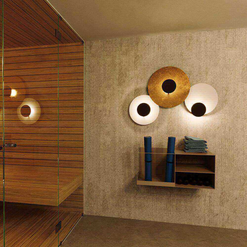 s.luce Lâmpada de parede e teto LED Plate em banheiro moderno com sauna e detalhes em madeira.