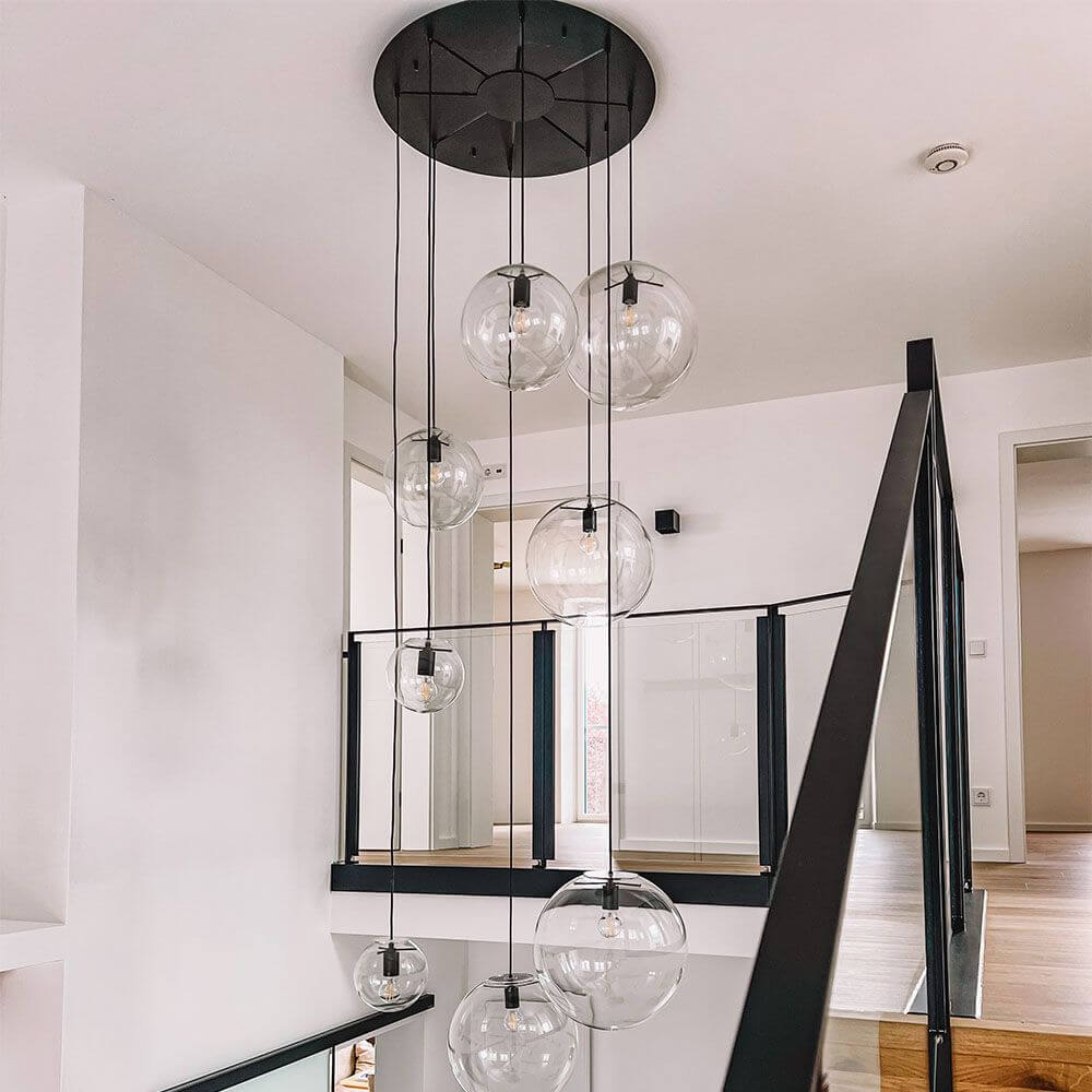 s.luce Modular Mehrfach-Baldachin mit transparenten Glaskugelleuchten im modernen Wohnraum.