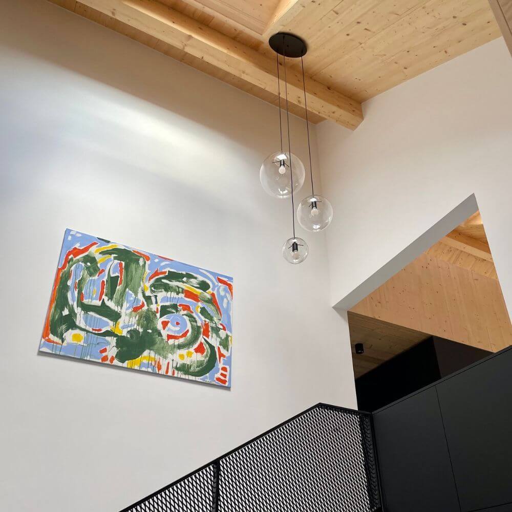 s.luce Orb 3-lamps Galerielamp Modular boven een modern kunstwerk in een lichte binnenruimte.