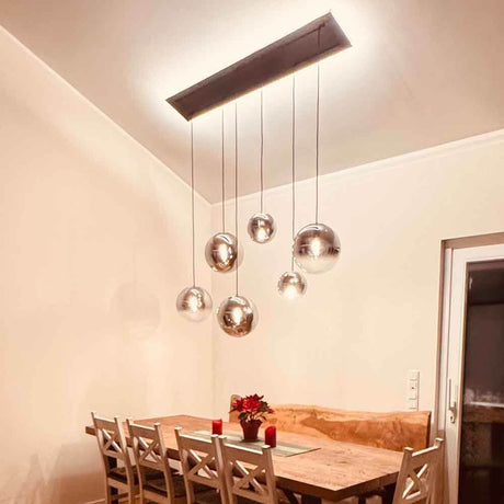 s.luce Orb Esstisch-Hängeleuchte 5-flammig 160cm über einem eleganten Esstisch