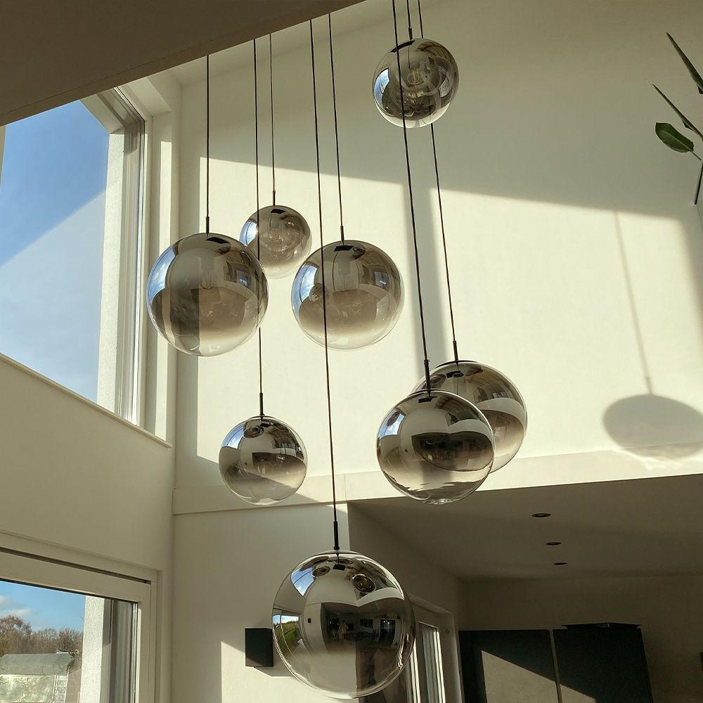s.luce Lampe de galerie Orb 8 flammes Modular dans un espace de vie moderne avec plusieurs boules scintillantes.