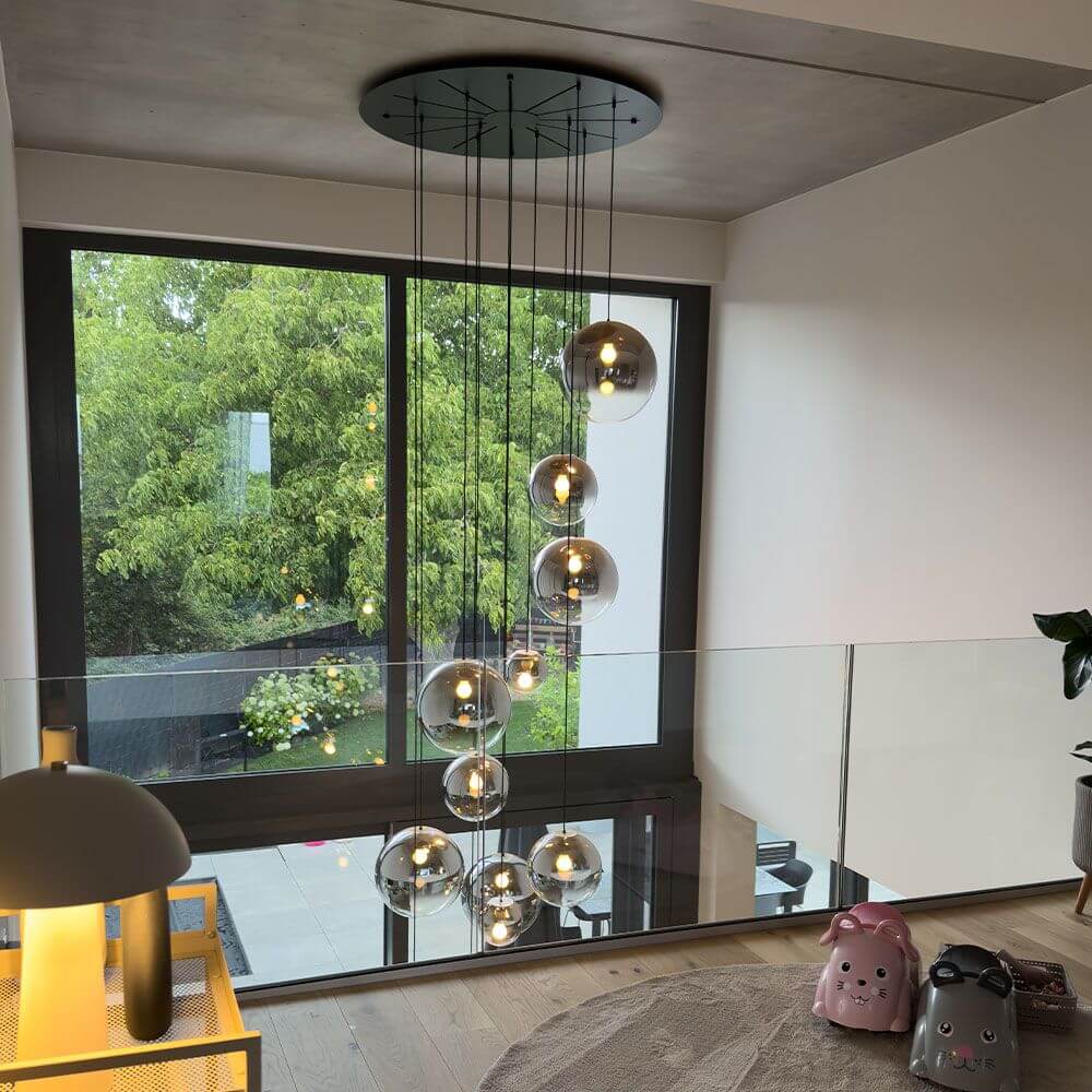 s.luce Orb Glaskugel Galerieleuchte 500cm Aufhängung Schwarz in modernem Raum mit vielen Fenstern.