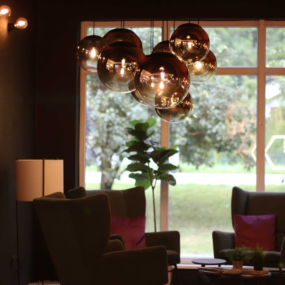 s.luce Orb glass ball pendant light in modern living space with stylish furniture and large windows