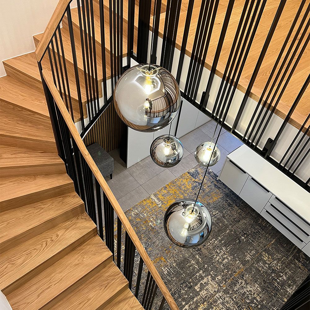 s.luce Orb glass ball pendant light in the staircase with elegant wooden stairs and modern design.