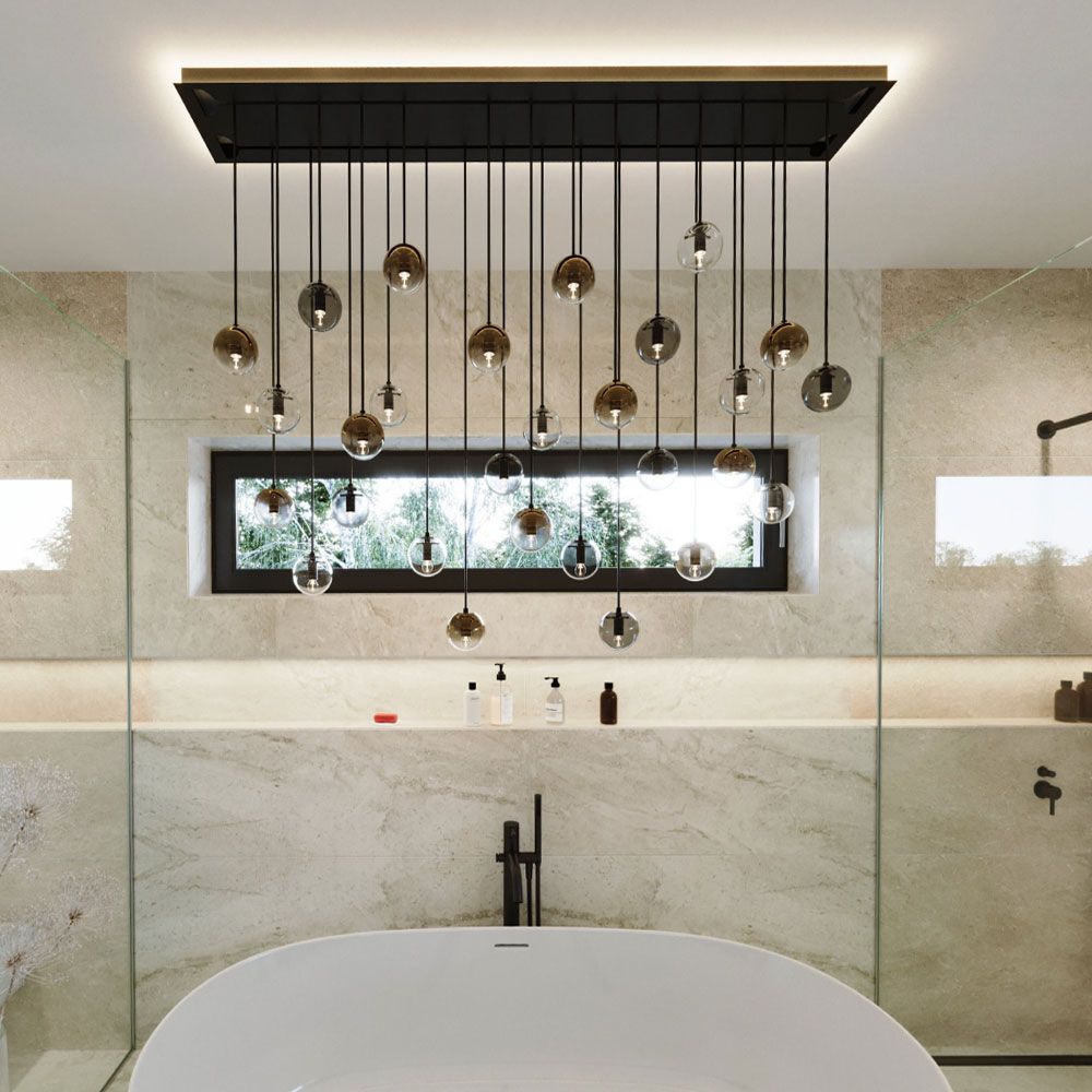 s.luce Lampada a sospensione Orb in vetro in moderno bagno sopra una vasca da bagno freestanding.