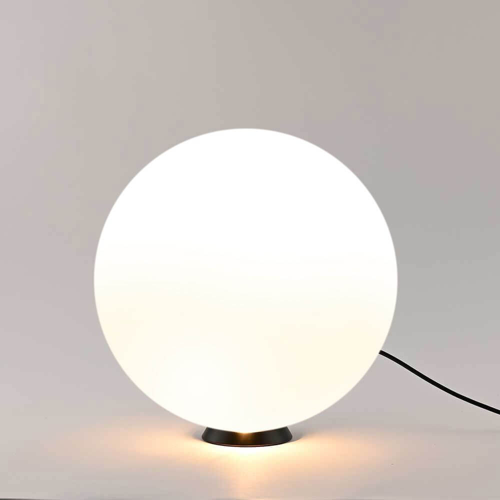 Orb Glaskugel Tischlampe mit minimalistischem Design und schwarzem Metallring, sanft leuchtend.