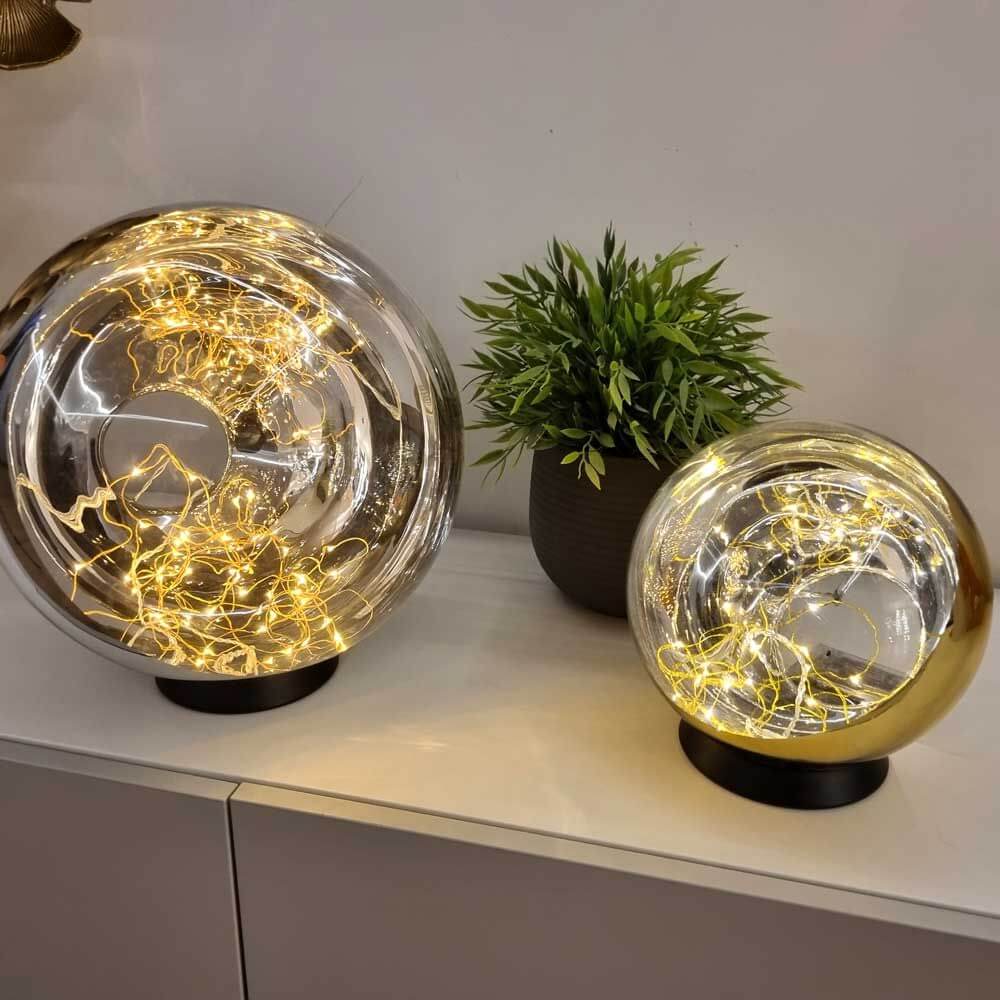 s.luce Orb LED-Dekolampe Glaskugel Ornament mit Lichterkette auf Tisch