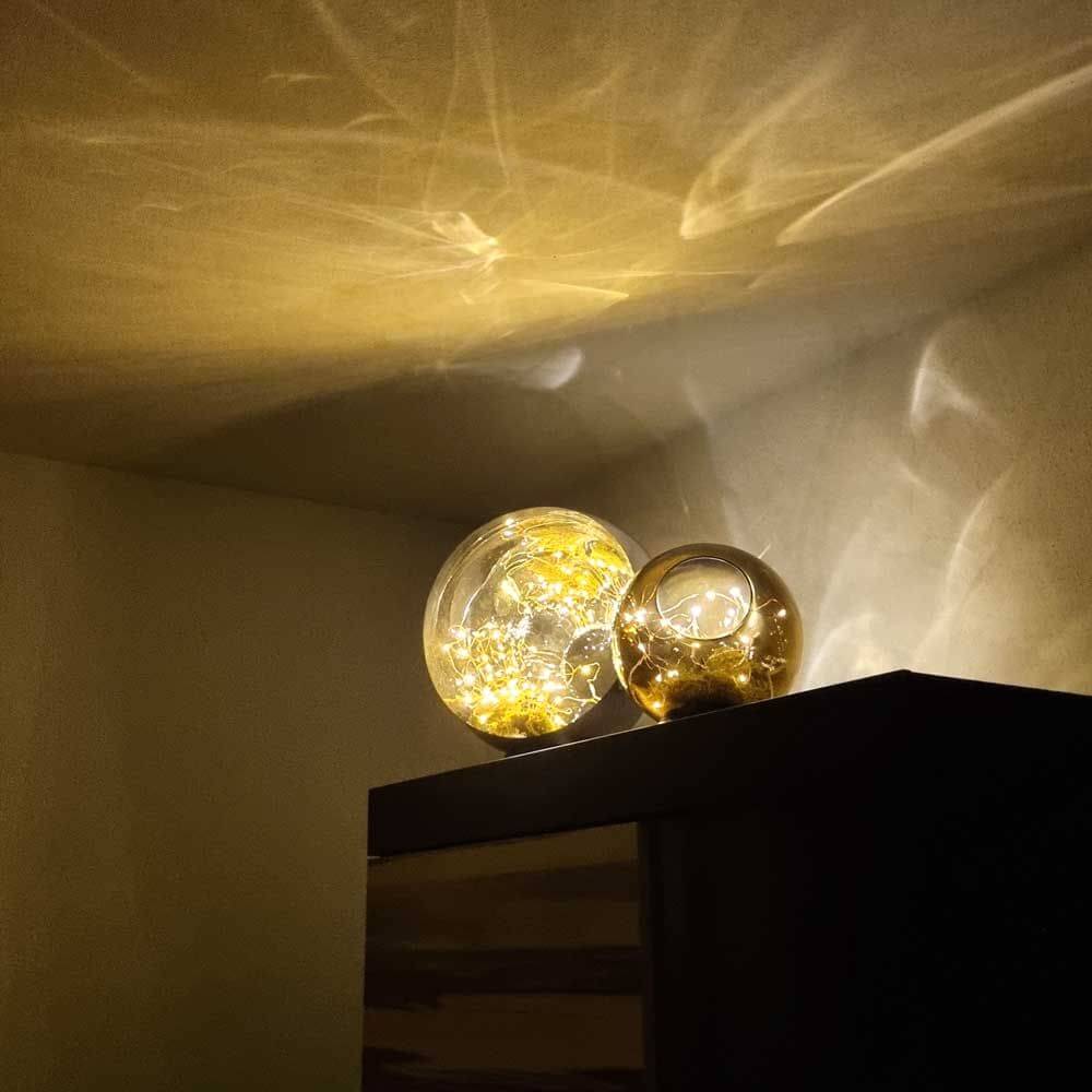 s.luce Orb LED-Dekolampe Glaskugel Ornament auf einem Tisch, dekorative Beleuchtung mit warmem Licht.