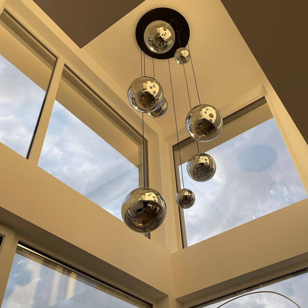 s.luce Orb XL Galerieleuchte 8-flammig mit Modular Baldachin in modernem Wohnraum mit großen Fenstern.