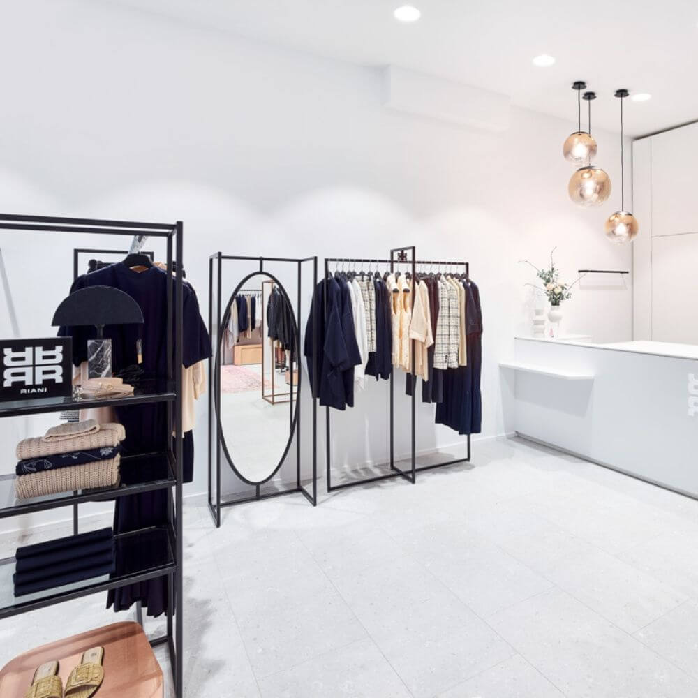 Modernes Bekleidungsgeschäft mit eleganten Kleidungsstücken und stilvollen Pendelleuchten.