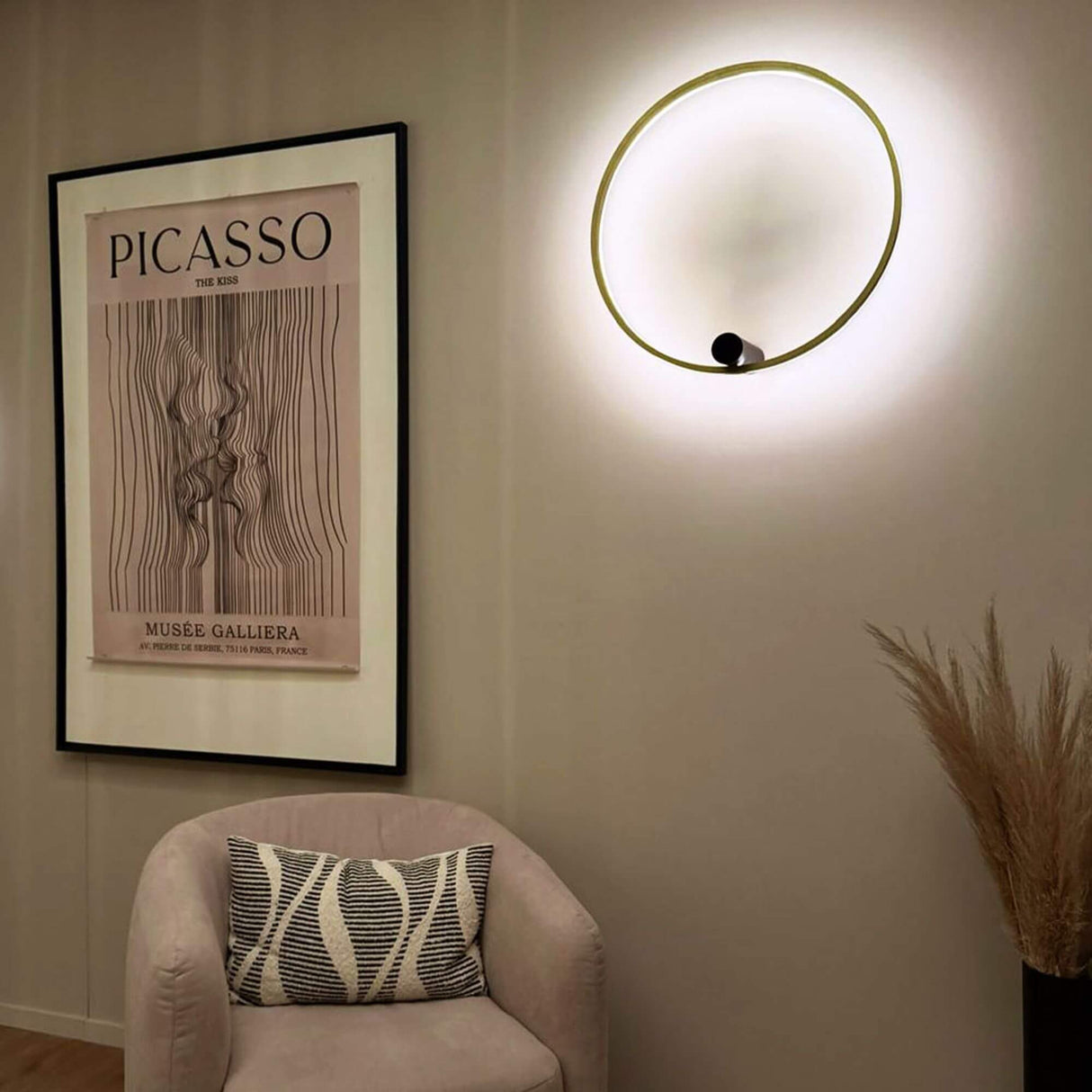 s.luce Ring Air LED wall light & ceiling lamp Ø 60cm above a chair in a modern living space with artwork