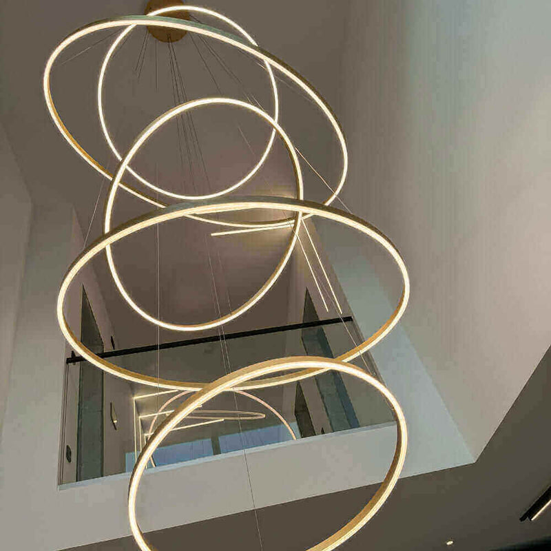 Moderne LED-Deckenleuchte mit mehreren schwebenden Ringen in einem eleganten Raum.