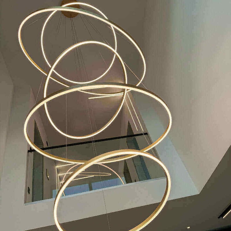 Moderne LED-Deckenleuchte mit mehreren schwebenden Ringen in einem eleganten Raum.
