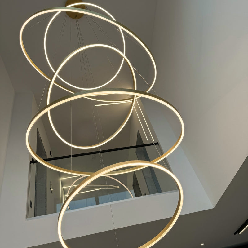 Moderne LED-Deckenleuchte mit mehreren schwebenden Ringen in einem eleganten Raum.